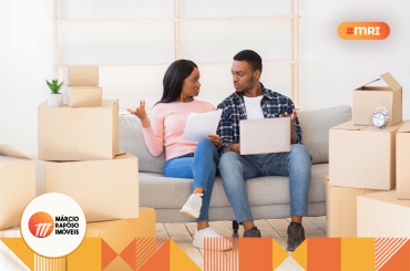 casal sentado no sofá conversando financiar ou alugar.