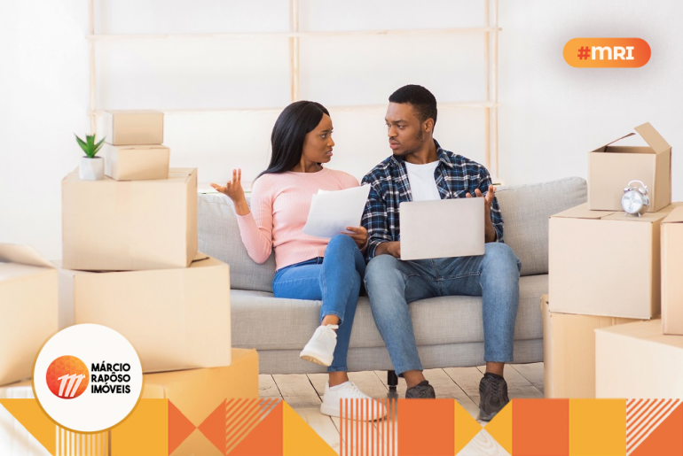 casal sentado no sofá conversando financiar ou alugar.