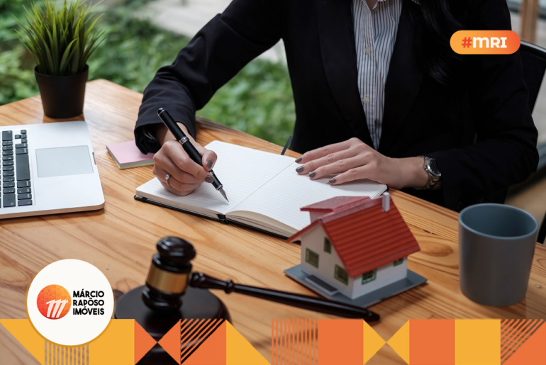 advogada escrevendo algo em um caderno. em cima da mesa, um martelo de direito, notebook, caneca, planta. imóveis de herança