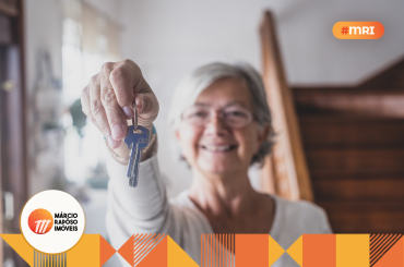 idosa segurando a chave de um imóvel