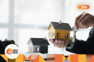 consultor com chaves na mão e uma casa de brinquedo. compra ou aluguel de imóveis