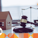 martelo do direito, balança e casa de brinquedo na mesa.