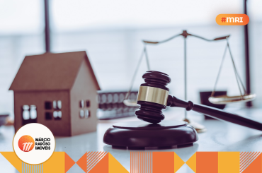 martelo do direito, balança e casa de brinquedo na mesa.